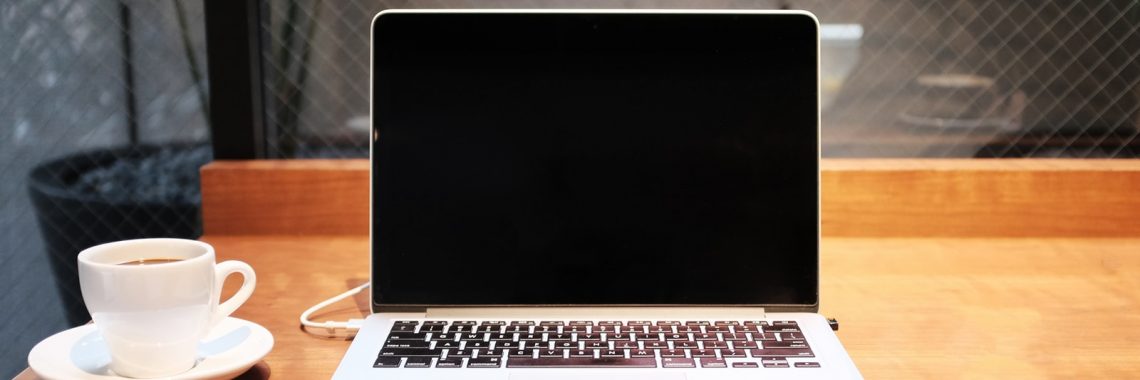 laptop computer beside coffee mug
